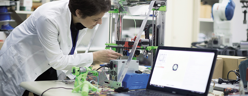 Female engineer working at machine